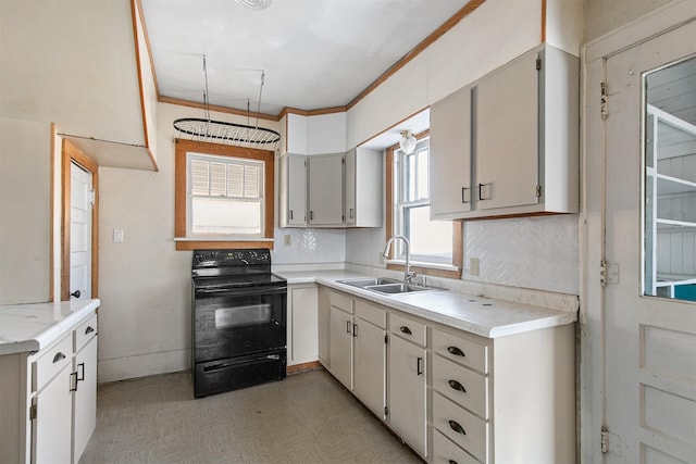 kitchen with electric range, sink, crown molding, and white cabinetry