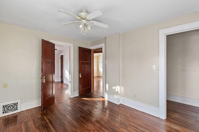 unfurnished room with ceiling fan and dark wood-type flooring