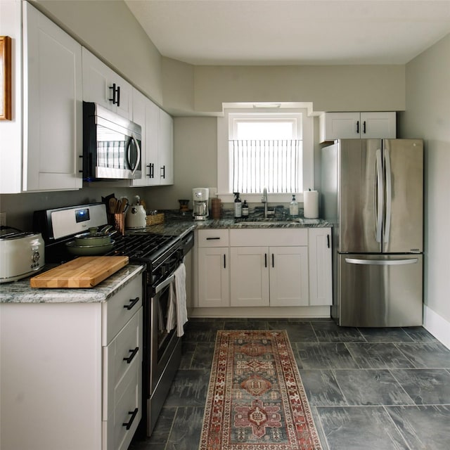 kitchen featuring appliances with stainless steel finishes, white cabinets, and sink