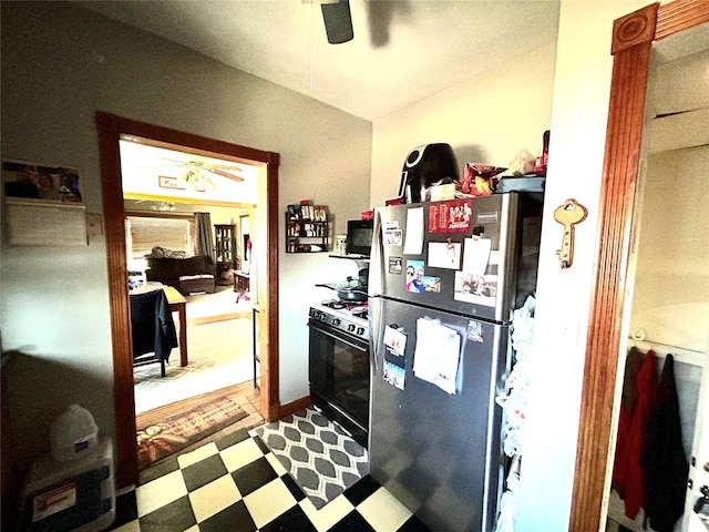 kitchen featuring ceiling fan, range with gas cooktop, and stainless steel refrigerator