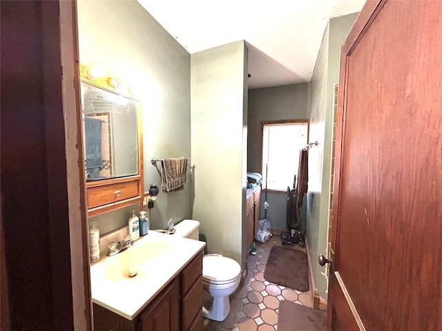 bathroom with toilet, tile patterned flooring, and vanity