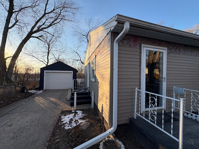 property exterior at dusk with a garage and an outbuilding