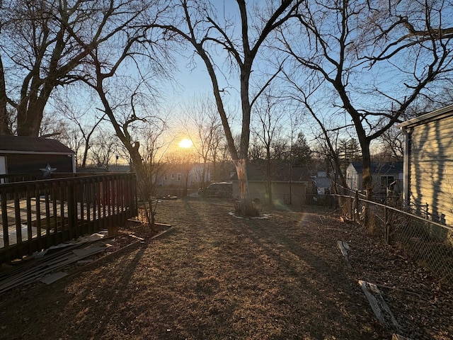 yard at dusk featuring a deck