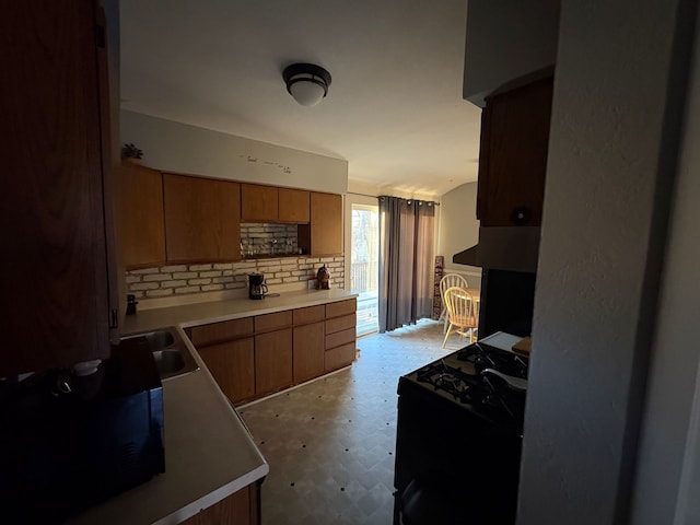 kitchen featuring sink, backsplash, and black range with gas stovetop