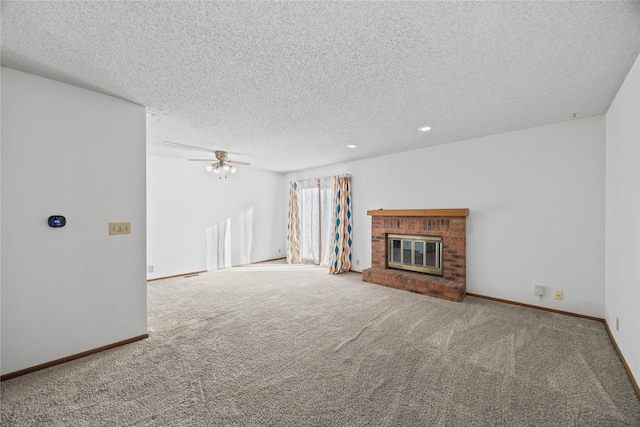 unfurnished living room featuring a brick fireplace, a textured ceiling, ceiling fan, and carpet flooring