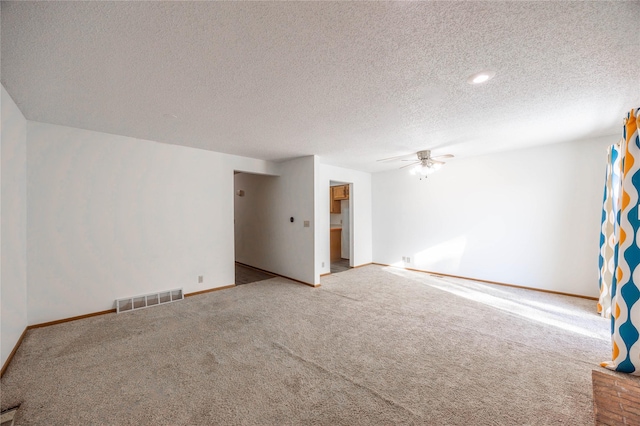 empty room featuring carpet, ceiling fan, and a textured ceiling