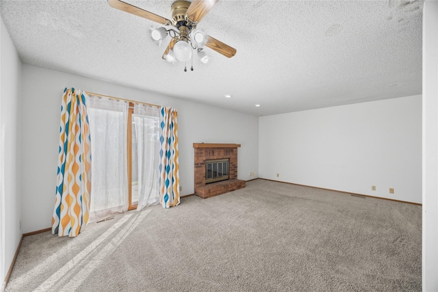 unfurnished living room with a textured ceiling, a brick fireplace, carpet flooring, and ceiling fan