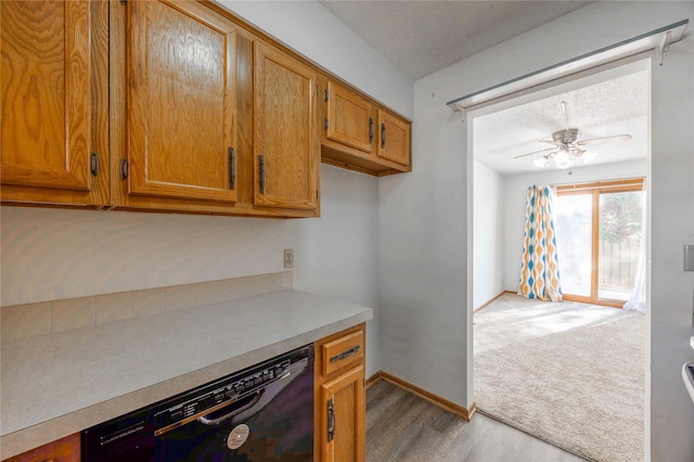 kitchen featuring a textured ceiling, ceiling fan, light carpet, and dishwasher