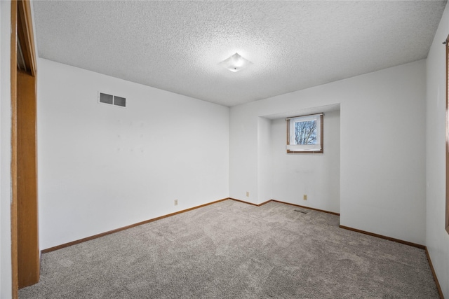 unfurnished room featuring light colored carpet and a textured ceiling