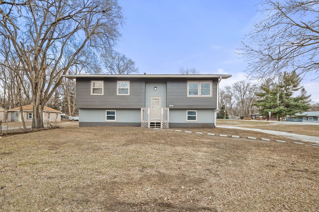 back of house featuring a lawn