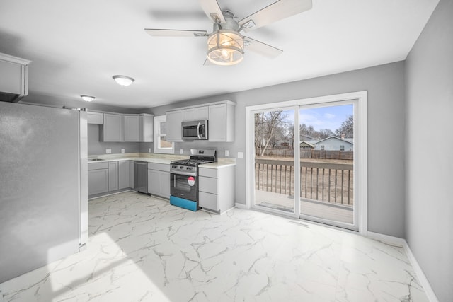 kitchen featuring ceiling fan, gray cabinets, and stainless steel appliances