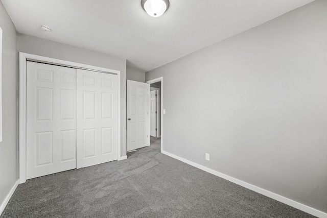 unfurnished bedroom with a closet and dark carpet