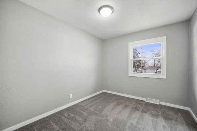 carpeted spare room with a textured ceiling