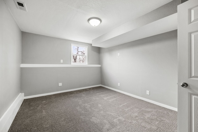 empty room with a textured ceiling and carpet floors