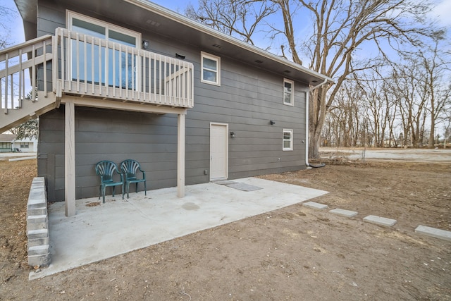 rear view of property featuring a balcony and a patio