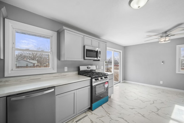 kitchen featuring ceiling fan, appliances with stainless steel finishes, and gray cabinetry