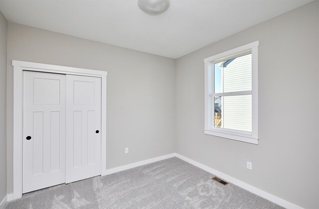 unfurnished bedroom featuring carpet floors and a closet