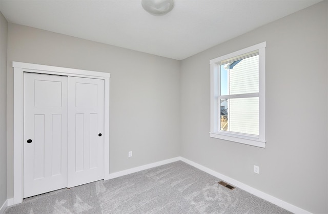 unfurnished bedroom featuring carpet flooring and a closet