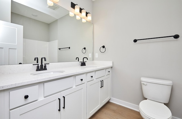 bathroom featuring vanity, a shower, hardwood / wood-style floors, and toilet