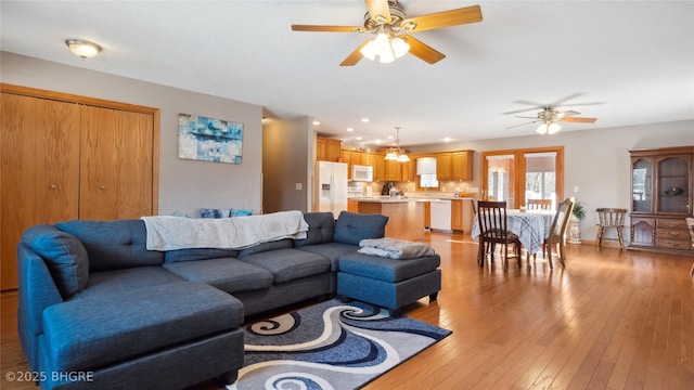 living room featuring ceiling fan and light hardwood / wood-style flooring