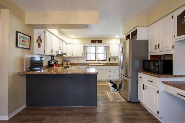 kitchen with dark wood-type flooring, white cabinetry, stainless steel appliances, sink, and kitchen peninsula