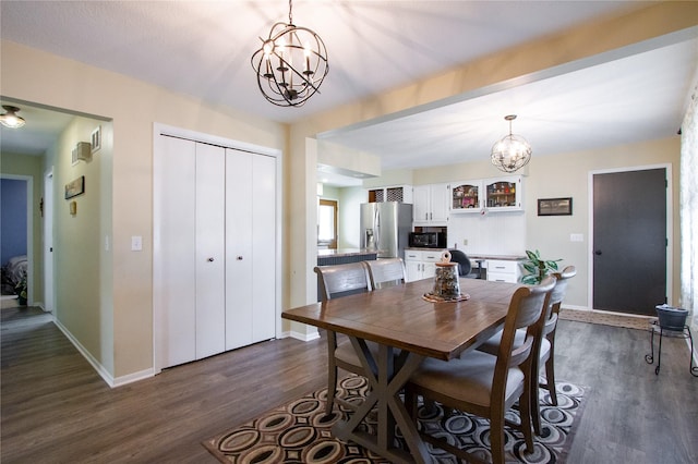 dining area with dark wood-type flooring and a chandelier