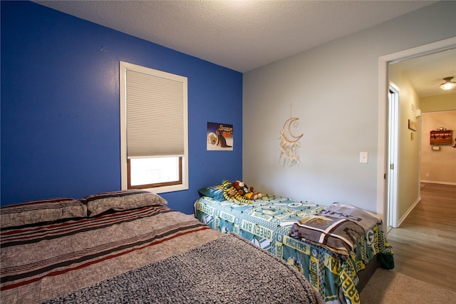 bedroom featuring a textured ceiling and hardwood / wood-style flooring