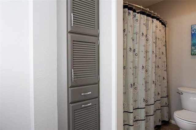 bathroom featuring toilet and a shower with curtain