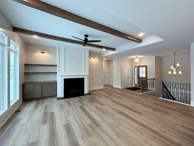 unfurnished living room with light wood finished floors, a fireplace, visible vents, and beamed ceiling