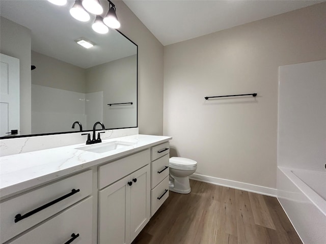 full bathroom featuring baseboards, toilet, wood finished floors, walk in shower, and vanity