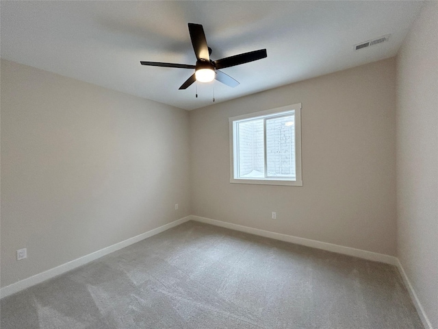 unfurnished room with light carpet, a ceiling fan, visible vents, and baseboards