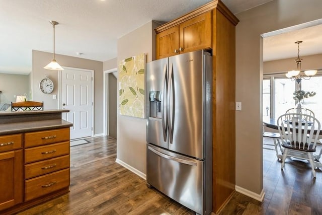 kitchen featuring decorative light fixtures, stainless steel fridge, dark hardwood / wood-style floors, and an inviting chandelier