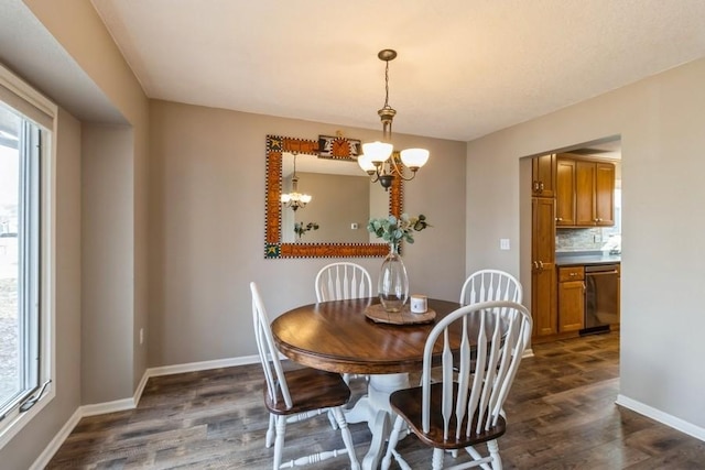 dining room featuring dark hardwood / wood-style floors, a healthy amount of sunlight, and an inviting chandelier