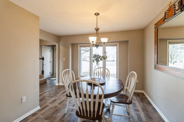 dining space featuring a textured ceiling, dark hardwood / wood-style floors, and a chandelier