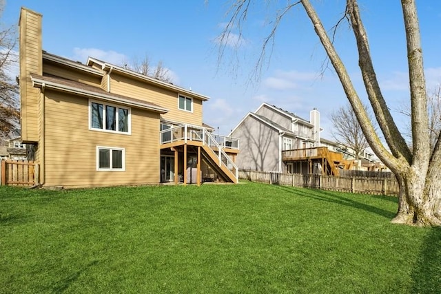 back of property featuring a deck and a lawn