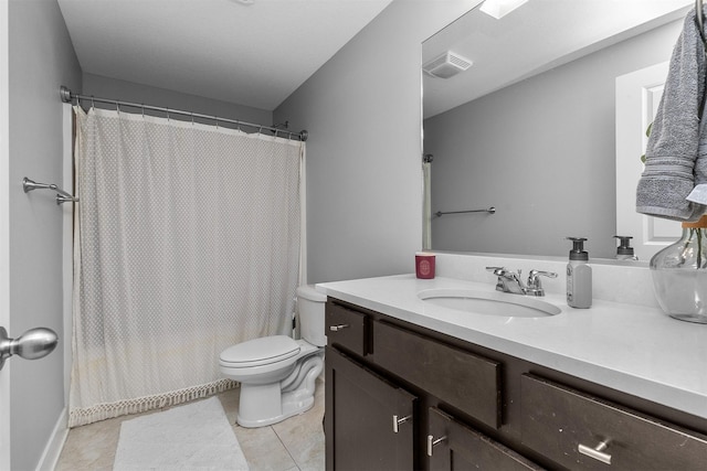 bathroom with toilet, vanity, and tile patterned floors