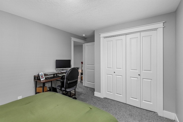 bedroom with a textured ceiling, a closet, and carpet floors