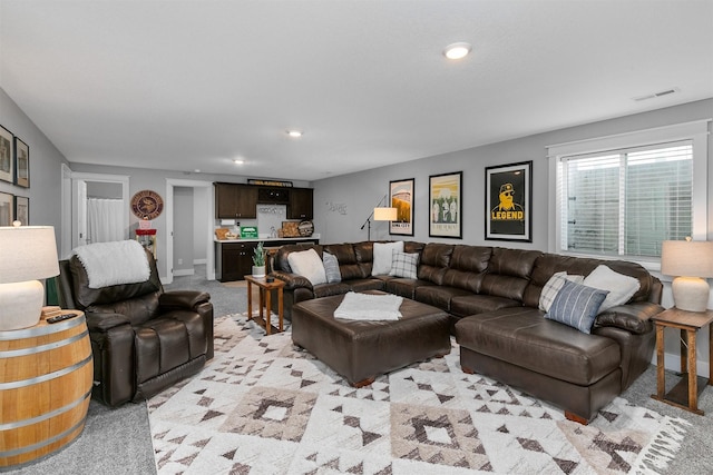 carpeted living room featuring bar area