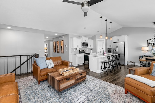 living room with ceiling fan, vaulted ceiling, dark hardwood / wood-style floors, and sink