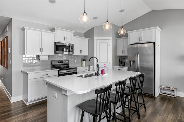 kitchen featuring white cabinetry, a center island with sink, stainless steel appliances, hanging light fixtures, and sink