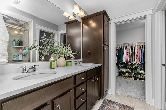 bathroom featuring a shower with shower door, vanity, and tile patterned flooring