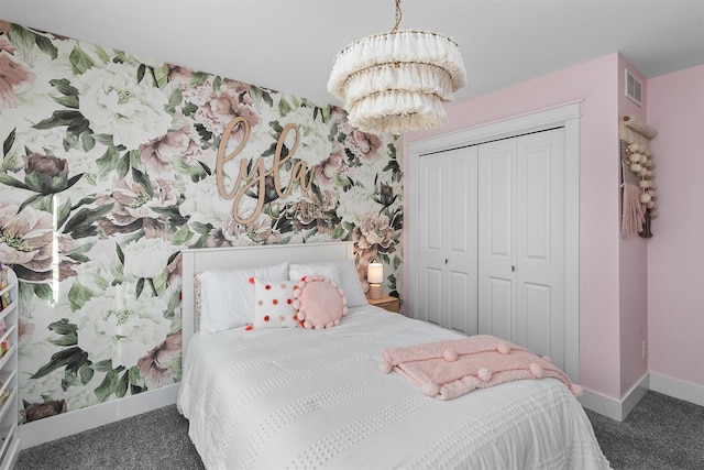 bedroom featuring a closet, an inviting chandelier, and dark colored carpet