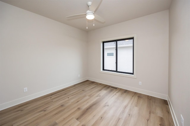 unfurnished room featuring baseboards, visible vents, ceiling fan, and light wood-type flooring