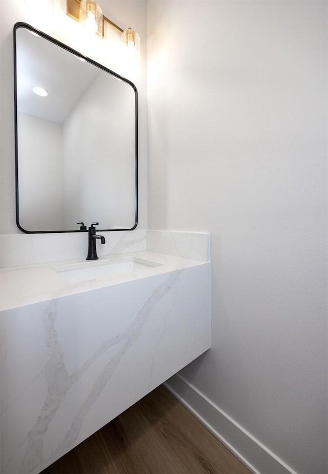 bathroom with baseboards, wood finished floors, and vanity