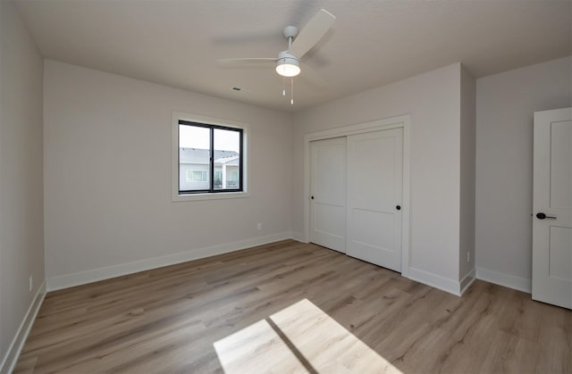 unfurnished bedroom with baseboards, light wood finished floors, ceiling fan, and a closet