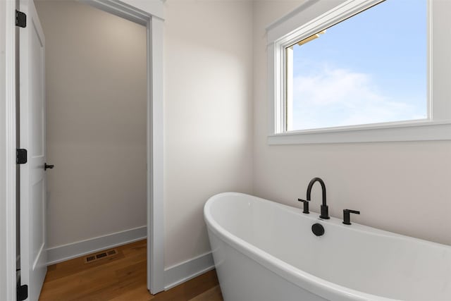 bathroom featuring a bath and hardwood / wood-style floors