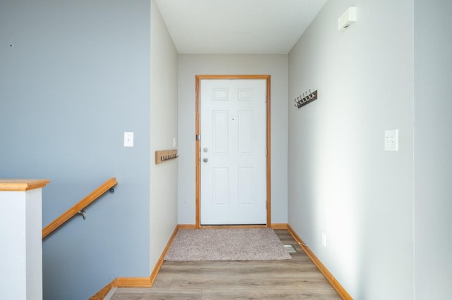 doorway with baseboards and wood finished floors