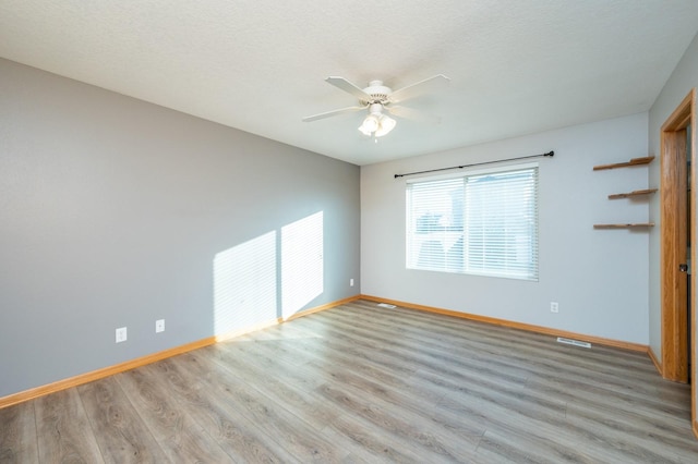 unfurnished room with ceiling fan, a textured ceiling, and light hardwood / wood-style flooring