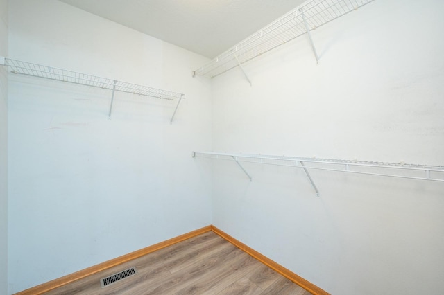 spacious closet featuring light wood-type flooring and visible vents