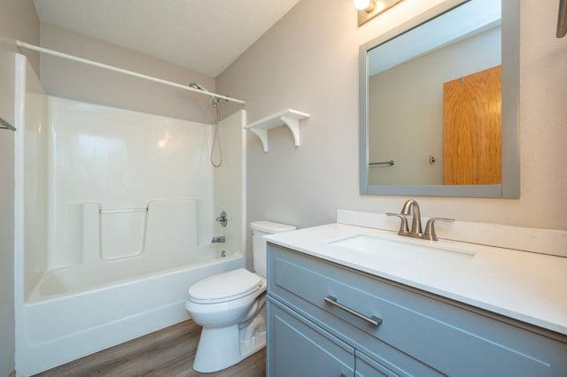 bathroom with vanity, washtub / shower combination, wood finished floors, and toilet